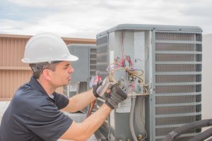 Hvac,technician,working,on,a,capacitor,part,for,condensing,unit.